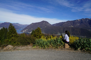 Young girl enjoying lake view on peak of mountain. Tourist traveler background valley landscape view mockup.