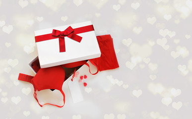 Woman lingerie in gift box decorated red ribbon with message card for text over holiday background...