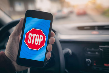 Mobiltelefon mit Stopschild auf Display im Auto
