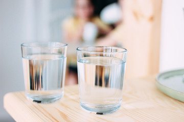 Two glasses of clean water, children in the background
