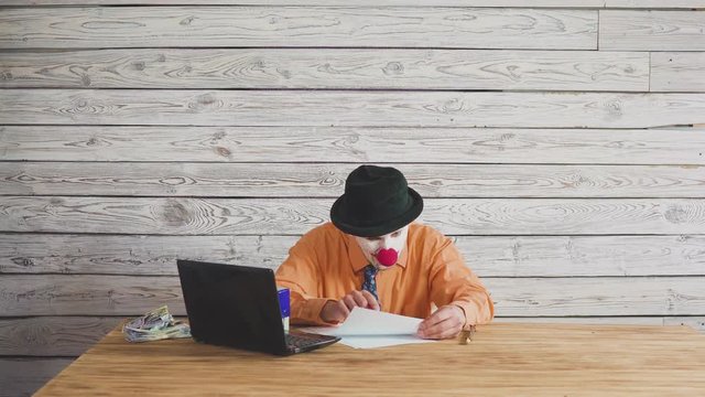 A clown manager or official signing a contract and has a stack of money