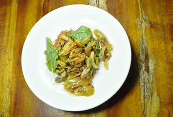 spicy stir fried mussel with basil leaf on plate