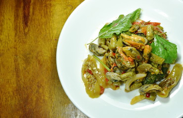 spicy stir fried mussel with basil leaf on plate
