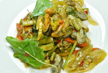 spicy stir fried mussel with basil leaf on plate