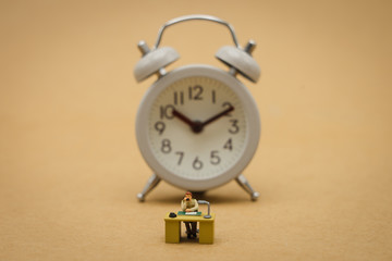 Miniature people businessmen and Vintage clock Sitting overtime "OT". using as background business concept and overtime concept with copy space  for your text or design.