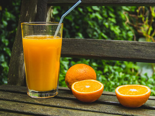 Orange juice in the garden, sweet natural refreshment, outdoors, close up, healthy lifestyle concept