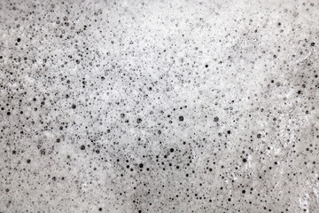 White foam background and texture with soap bubbles or shampoo for hygiene and washing