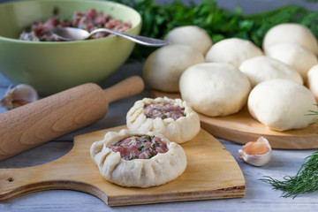 Cooking pies with meat and onions. Whites on a cutting board.