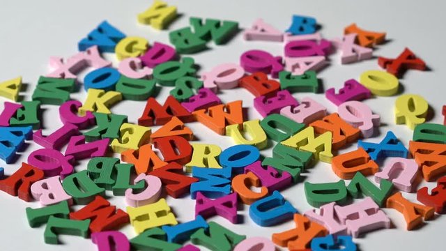 Alphabet letters on wooden scrabble pieces scattered