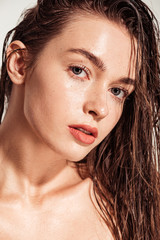 beautiful young woman with coral lips and wet hair looking at camera - obrazy, fototapety, plakaty