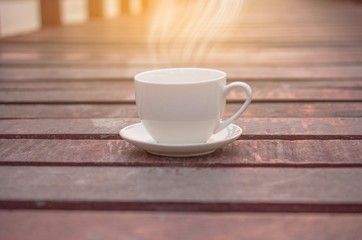 White cup of coffee on wooden background for coffee drink concept