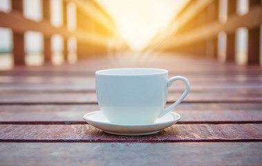 White cup of coffee on wooden background for coffee drink concept