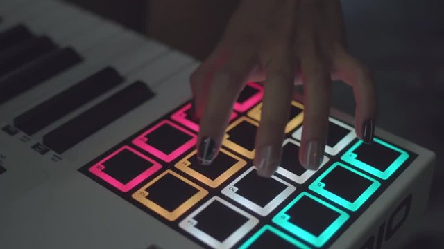 Drum machine in the night club playing live set. Stock. Fingers tapping drum pads on a digital beatmaker close-up. Dj starts playing music set in the club playing the drum machine