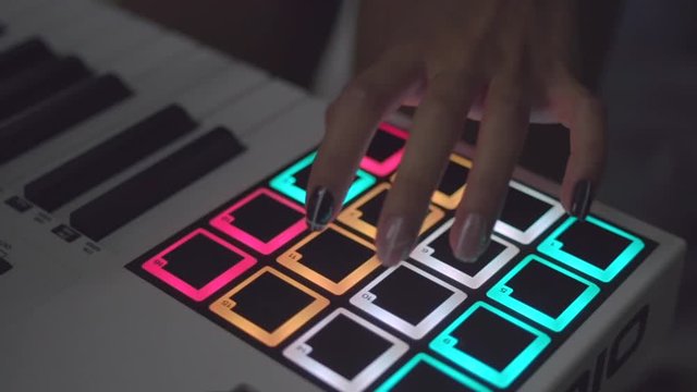 Drum machine in the night club playing live set. Stock. Fingers tapping drum pads on a digital beatmaker close-up. Dj starts playing music set in the club playing the drum machine