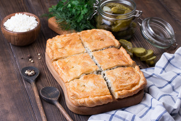 Homemade puff pie with pickled cucmbers and cottage cheese