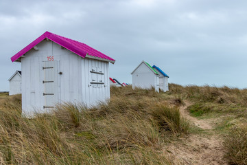 Fototapeta na wymiar Cabanes de plage en bois colorées à Gouville-Sur-Mer