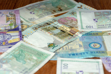 A mix of Omani Riyal Currency Bills spread out on the table.