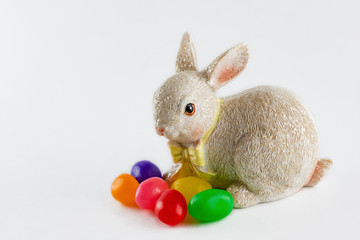 Close up of Easter bunny figurine with jelly beans isolated on white background.  Copy space.