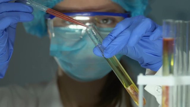 Lab scientist adding chemical agent to meat sample in tube, gmo food expertise