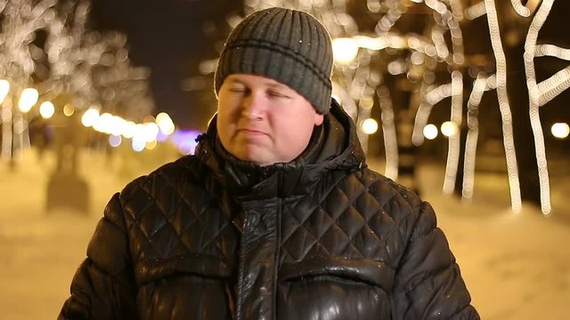Portrait of handsome man saying no by shaking head outdoors during cold winter night