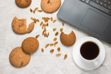 Homemade Oatmeal Cookies, Cup of Coffee and Laptop on a Light Stone Background. Student Weekdays