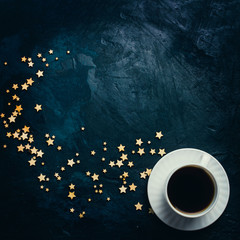 Cup of coffee and stars on a dark blue background. Concept of the Starry sky and Coffee. Flat lay, top view