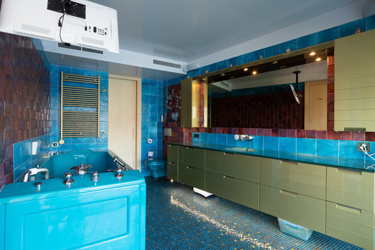 Blue bathroom with Jacuzzi and television