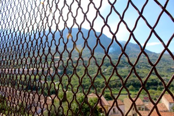 Naklejka premium Sun shining through fence in Cefalu, Sicily