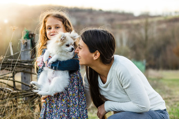 Happy countryside family with their cute white pomeranian dog
