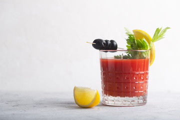 Cocktail Bloody Mary with ice, salt and snacks in glass on a table