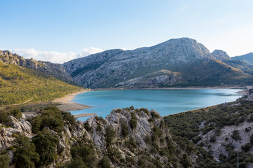 Fototapeta na wymiar Ein blauer Stausee am Torrent de Gorg auf Mallorca wird von Bergen umschlossen