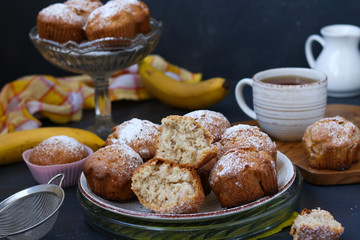 Muffins with bananas are located on plates against a dark background