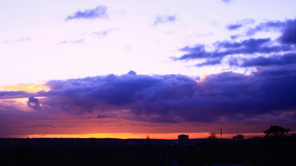 amazing sunset with cumulonimbus over the land. Cloudy landscape above dwelling and land 