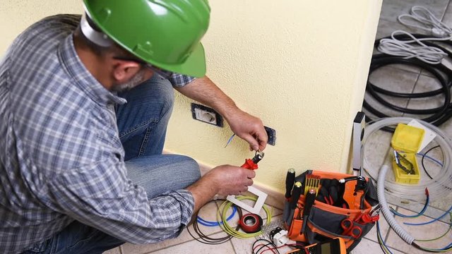 Electrician technician worker prepares the electric cable in a residential electrical system. Construction industry. Building. Footage. 