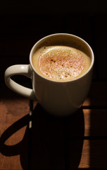 a close up of a coffee mug with a delicious capuccino with cream
