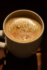 a close up of a coffee mug with a delicious capuccino with cream
