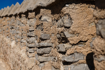 brown columns made of stones in one long row; The second column is highlighted with sharpness, while the front and back form a blurred background