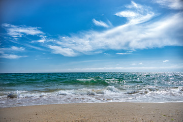 Fototapeta na wymiar on sea small waves of. Blue sky with clouds