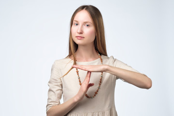 Young pretty woman tired and bored, making a timeout gesture
