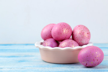 Easter. Pink easter eggs in a bowl on a blue wooden table. Happy easter. holidays.