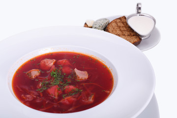 Ukrainian borsch with sour cream, bread with lard, the national dish. Photo Close-up on the white plate. Isolated