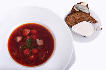 Ukrainian borsch with sour cream, bread with lard, the national dish. Photo Close-up on the white plate. Isolated