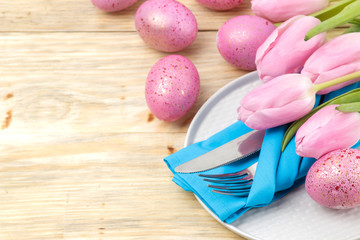 Easter. Easter table setting. Pink Easter eggs and flowers tulips on a natural wooden table. Happy easter. holidays.