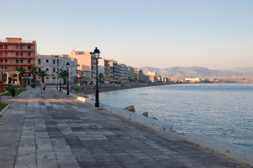 Obraz premium Wide view of embankment and beach at early morning on the Loutraki embankment with a dog