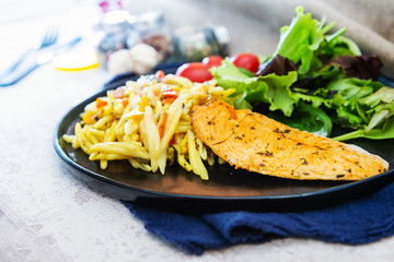 close-up of plate of pasta and chicken with lettuce