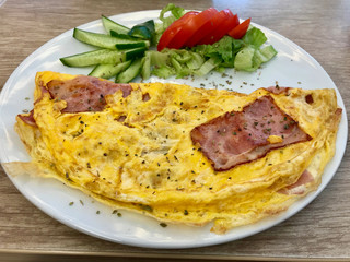 Omelette with Bacon served with Cucumber and Tomatoes.