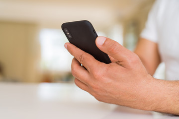 Close up of middle age man hands using smartphone at home