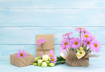 Chamomile and rose flowers and gift box on wooden background in Shabby Chic style