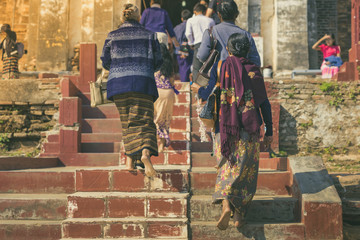 Backview of female tourists at ancient Pa Hto Taw Gyi Pagoda ruins at Mingun city near Mandalay, Myanmar.