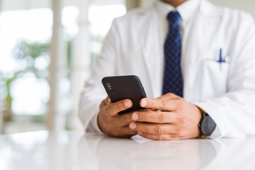 Close up middle age doctor man hands using smartphone